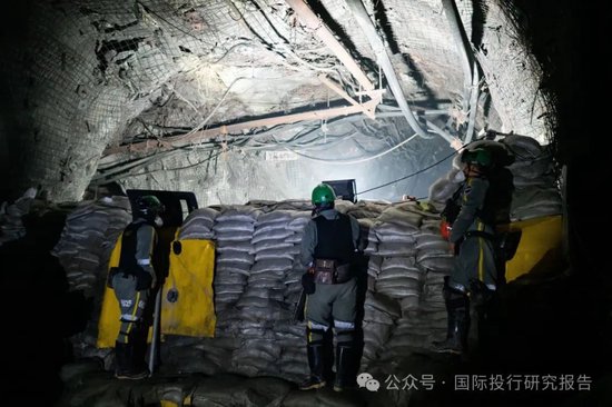 紫金矿业的私人安保武装警卫在沙袋路障后站岗